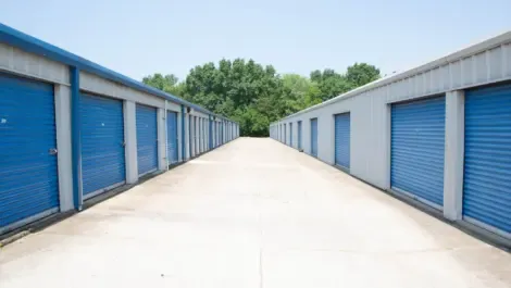 Row of outdoor drive-up storage units with metal roll-up doors