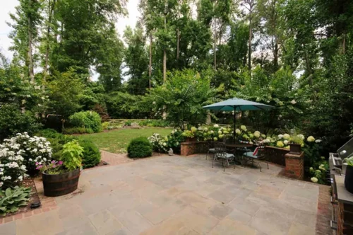 A backyard with natural shade and an umbrella.