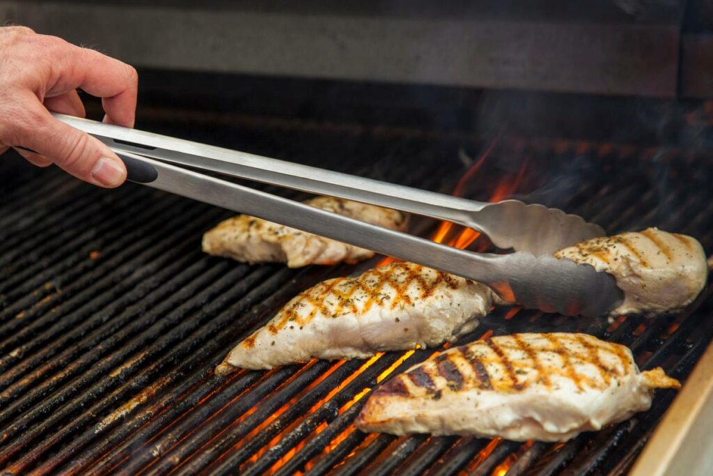 Chicken grilling on outdoor grill.